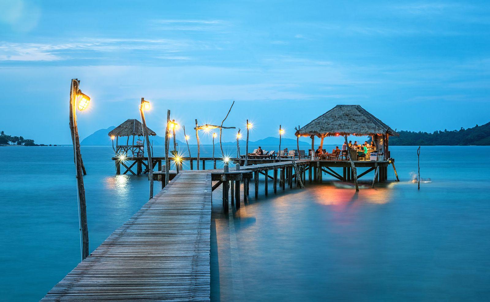 Illustrative waterfront pier and open-air pavilion at blue hour