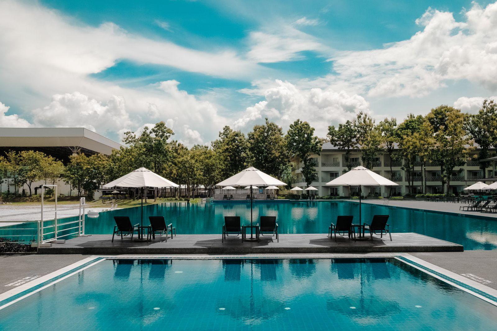 Illustrative pool terrace with loungers beneath a tropical sky