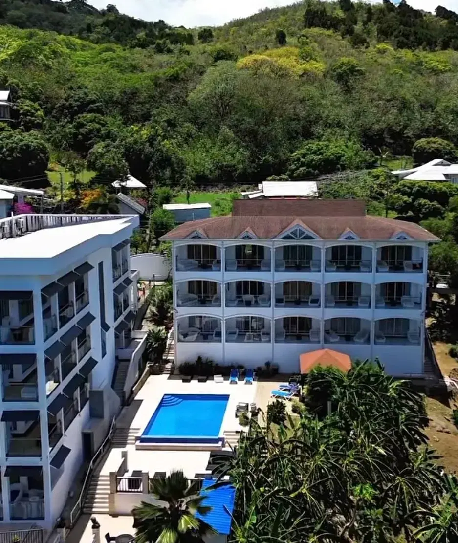 Aerial view of the hotel, pool deck and forested hills