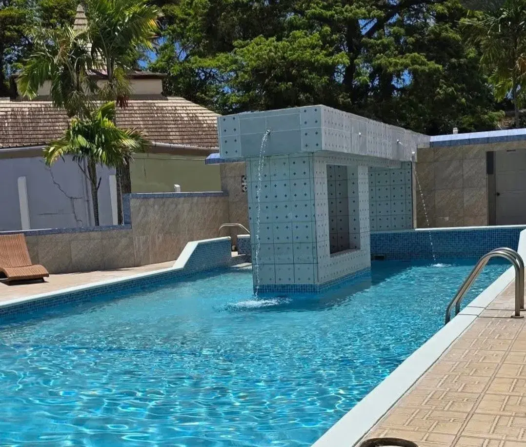 Tiled waterfall feature pouring into the turquoise pool