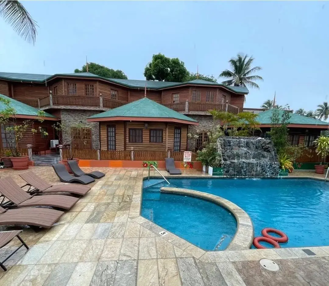 Pool deck with loungers beneath the two-storey log cabins