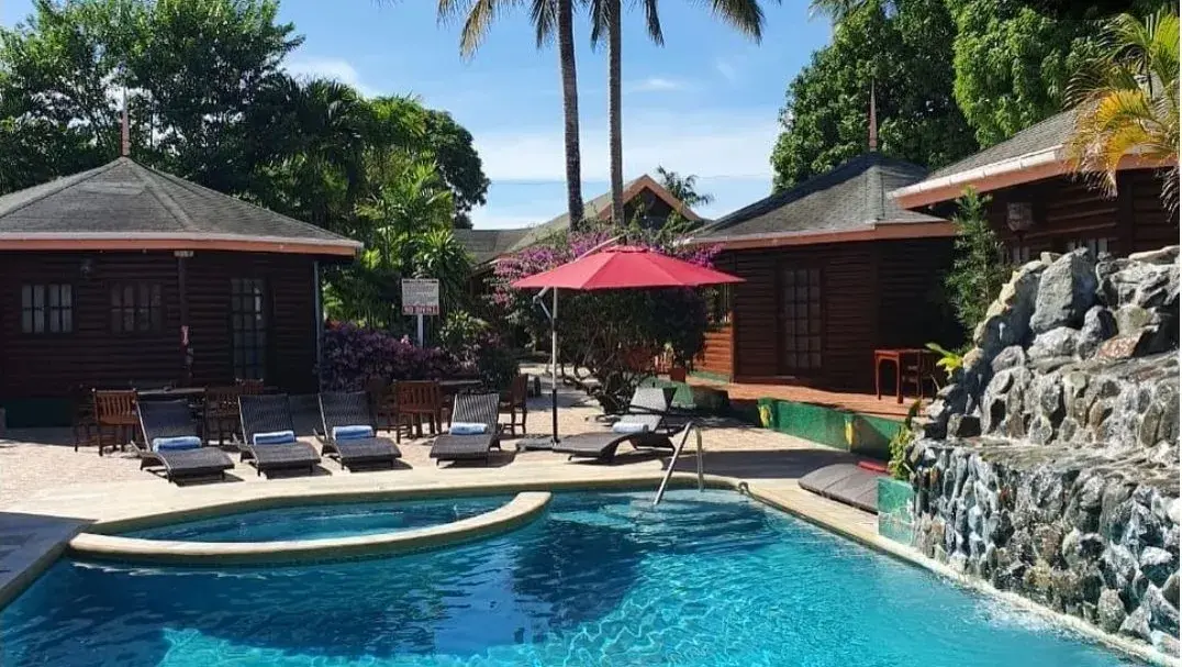 Loungers and umbrella beside the pool waterfall