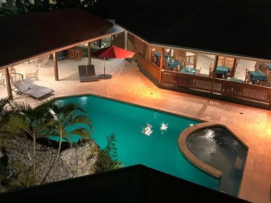 Night-lit pool beside the covered lounge deck