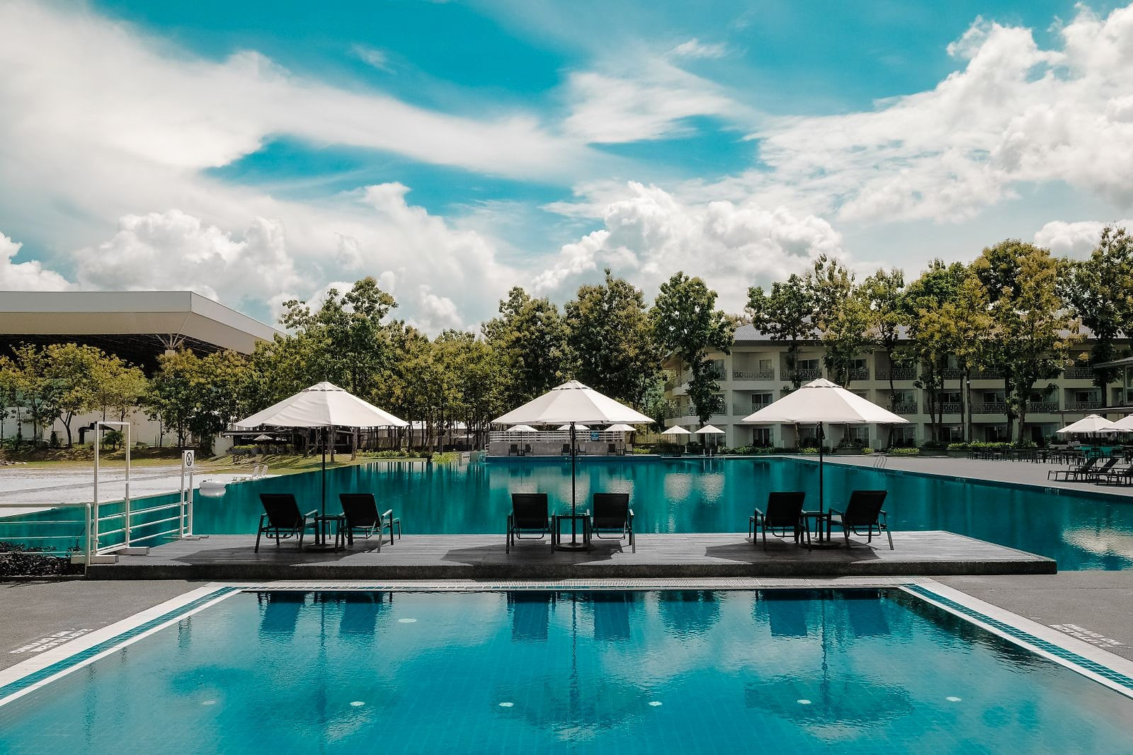 Pool terrace with loungers beneath a tropical sky