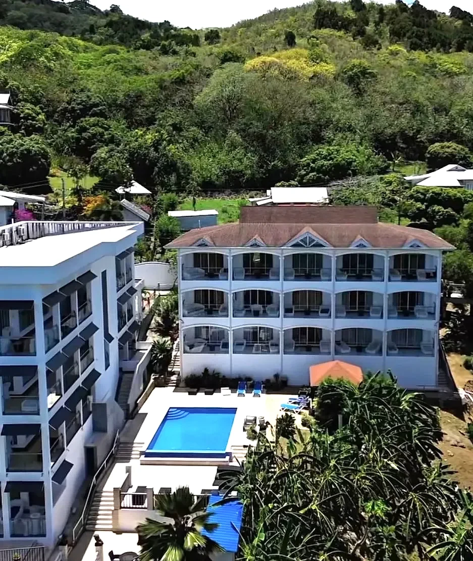 Aerial view of the hotel, pool deck and forested hills