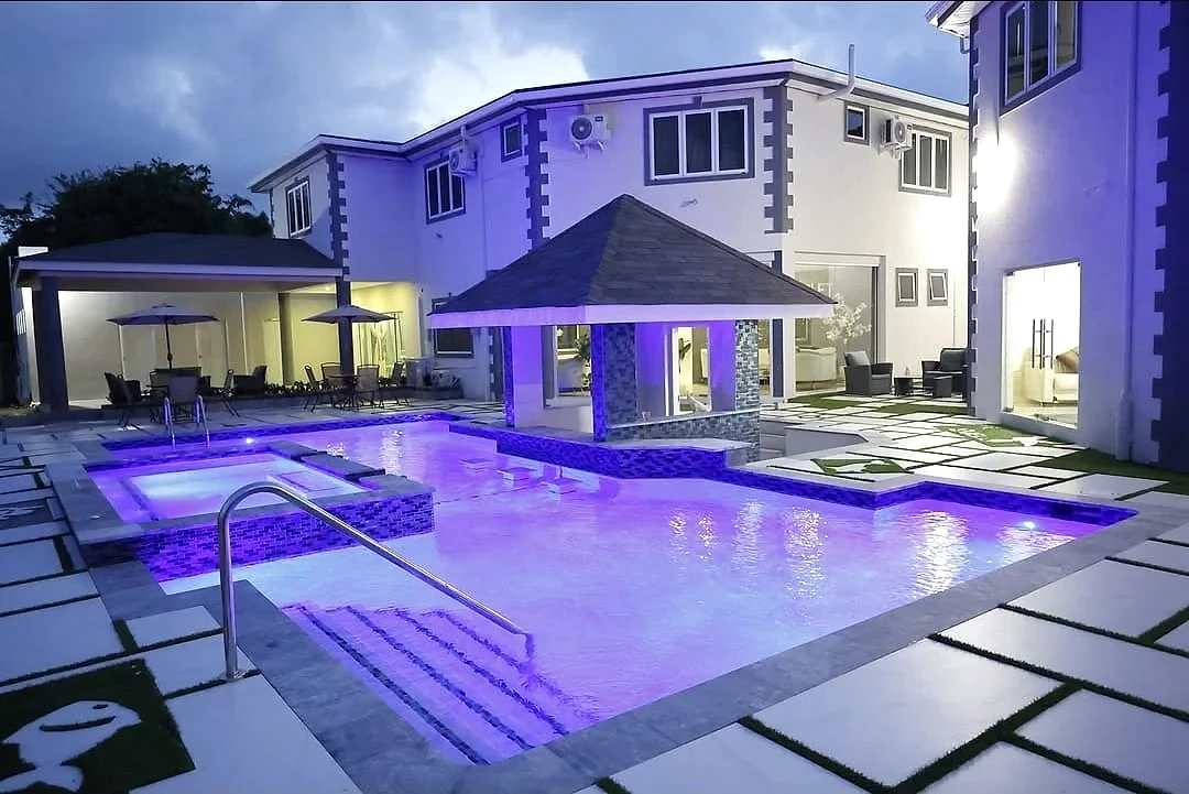 Courtyard pool and swim-up bar glowing with evening lights