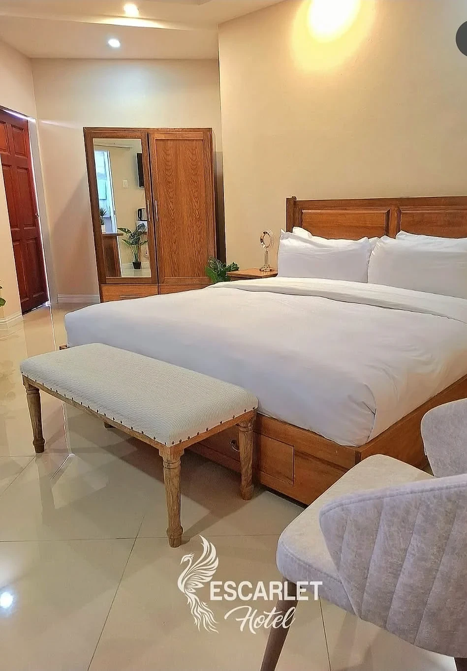 Escarlet Hotel guest room with crisp white bedding and timber furnishings