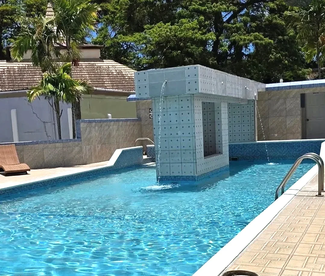 Tiled waterfall feature pouring into the turquoise pool