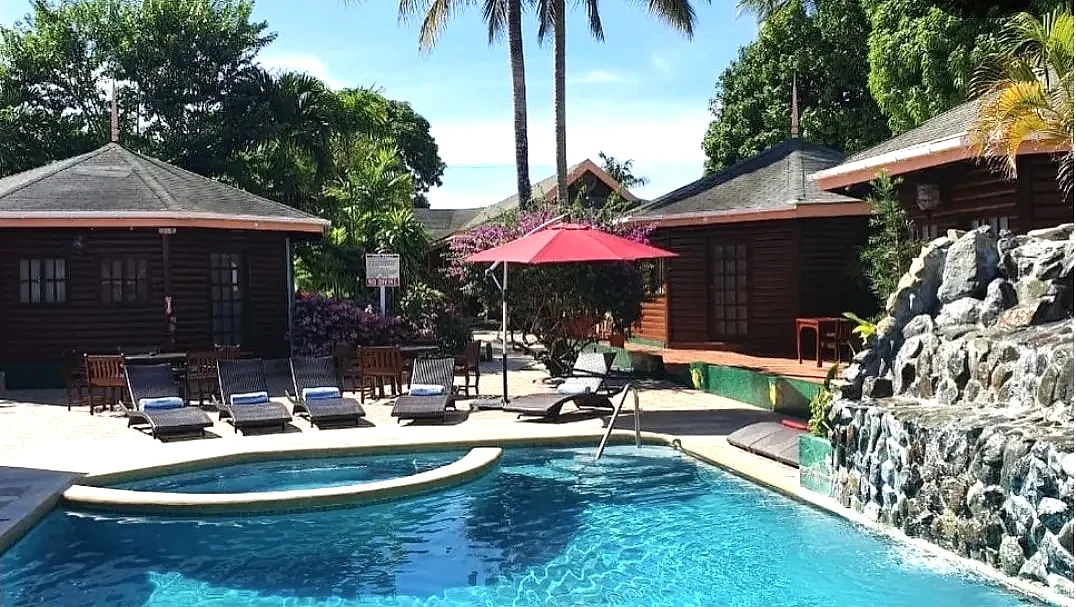Loungers and umbrella beside the pool waterfall