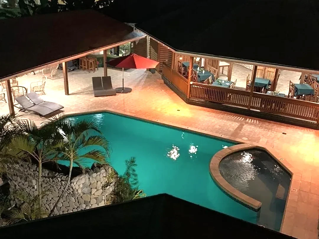 Night-lit pool beside the covered lounge deck